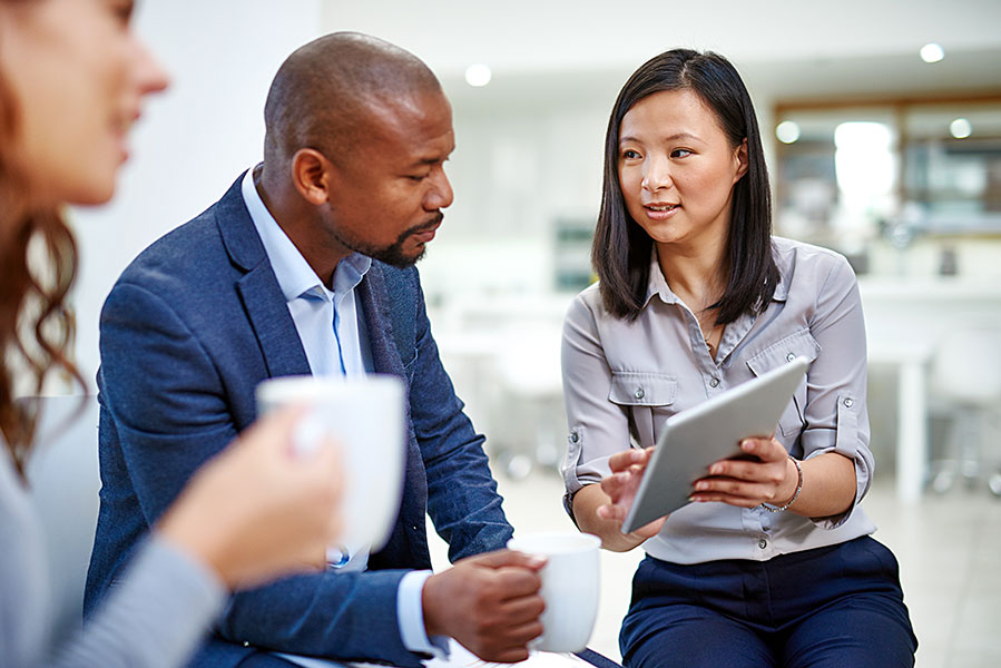 two analysts reviewing data on a tablet